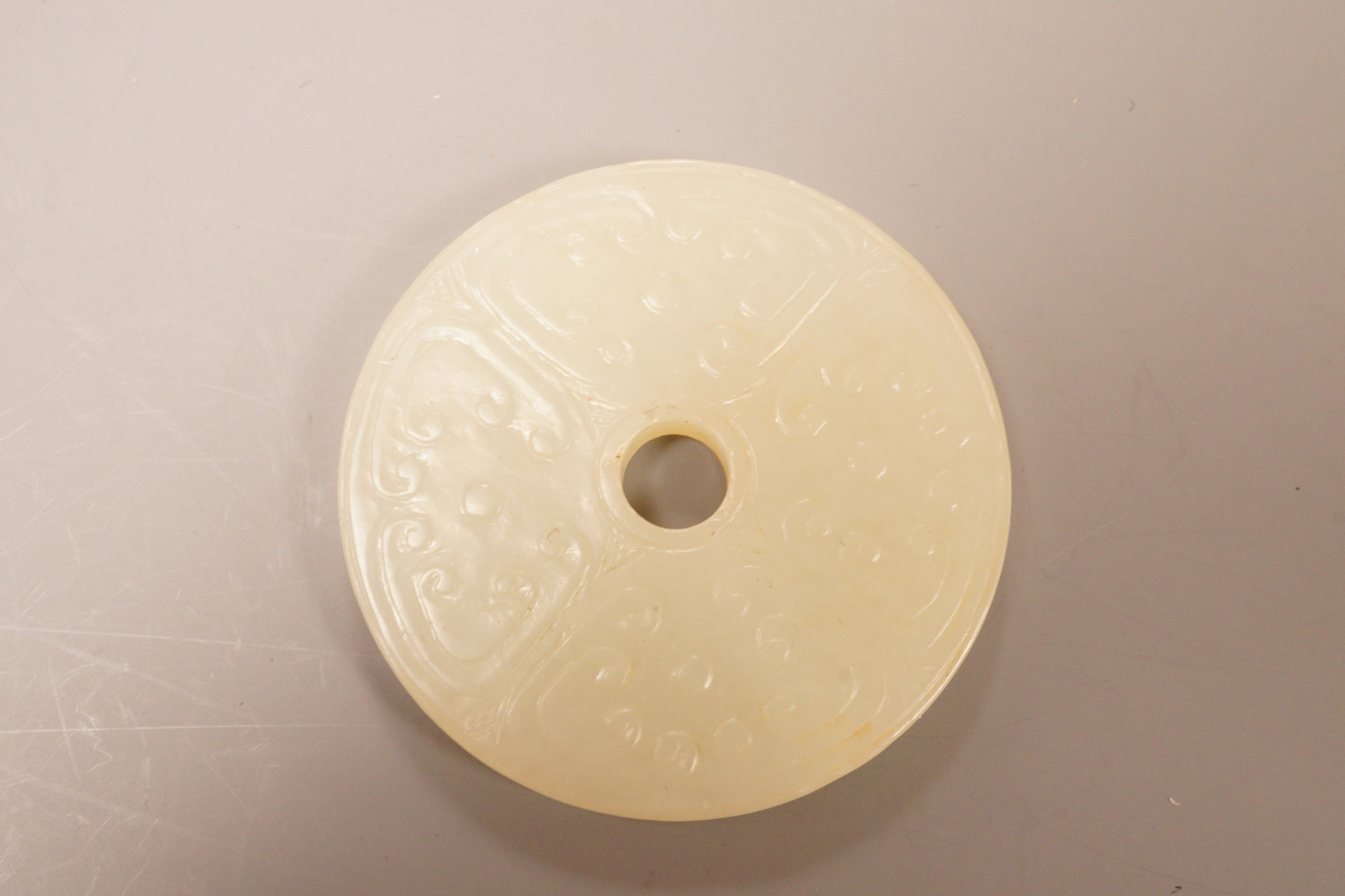 A Chinese pale celadon jade bi disc